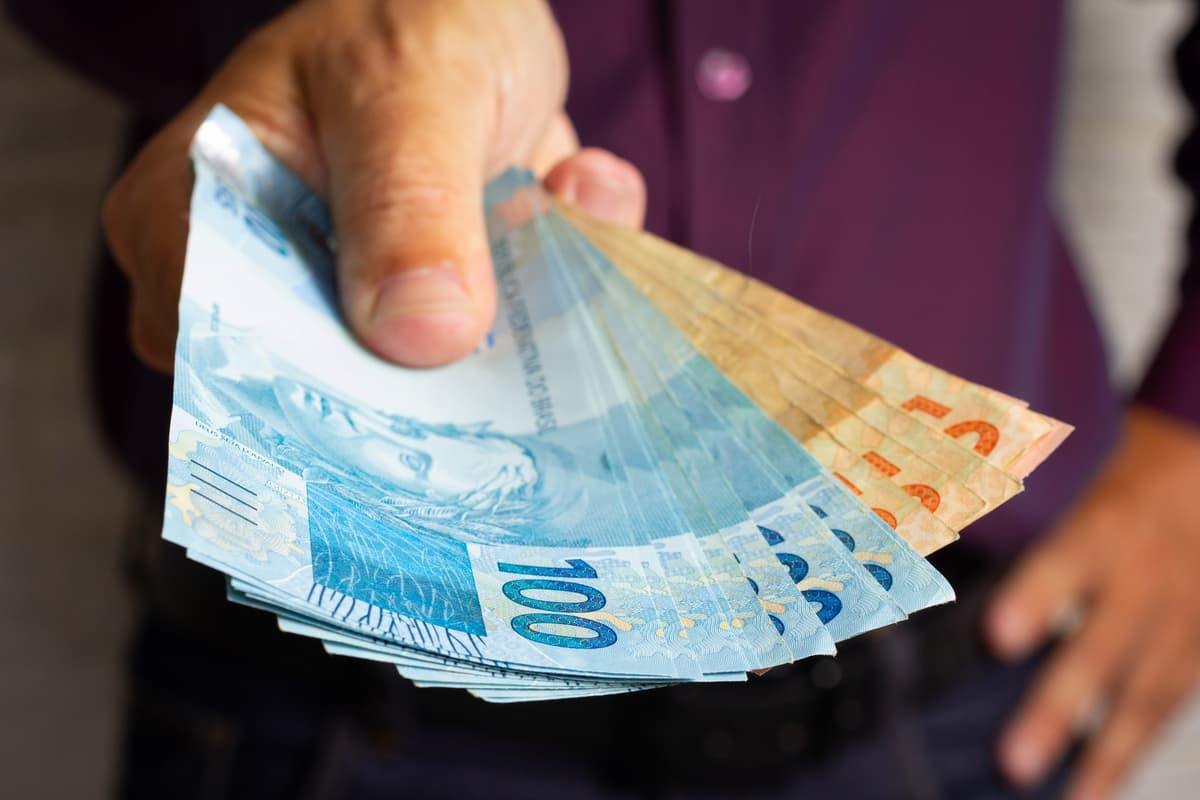 homem segurando dinheiro
